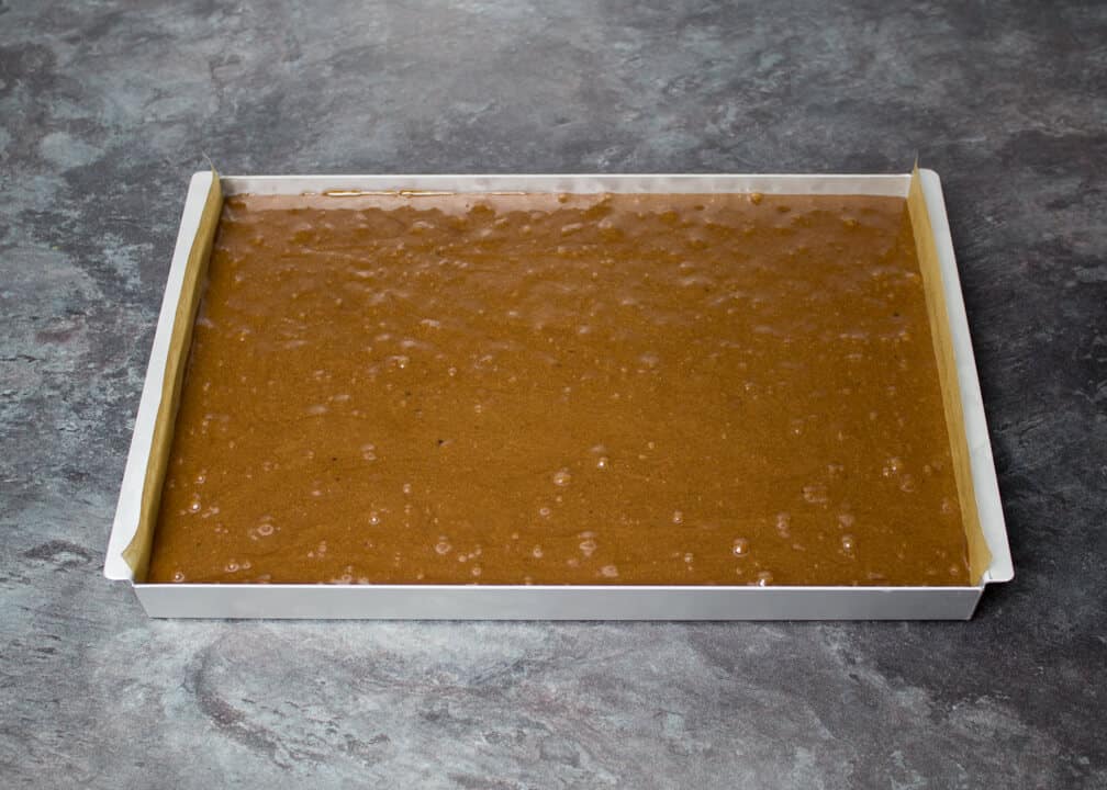 Brownie batter in a lined rectangular tin