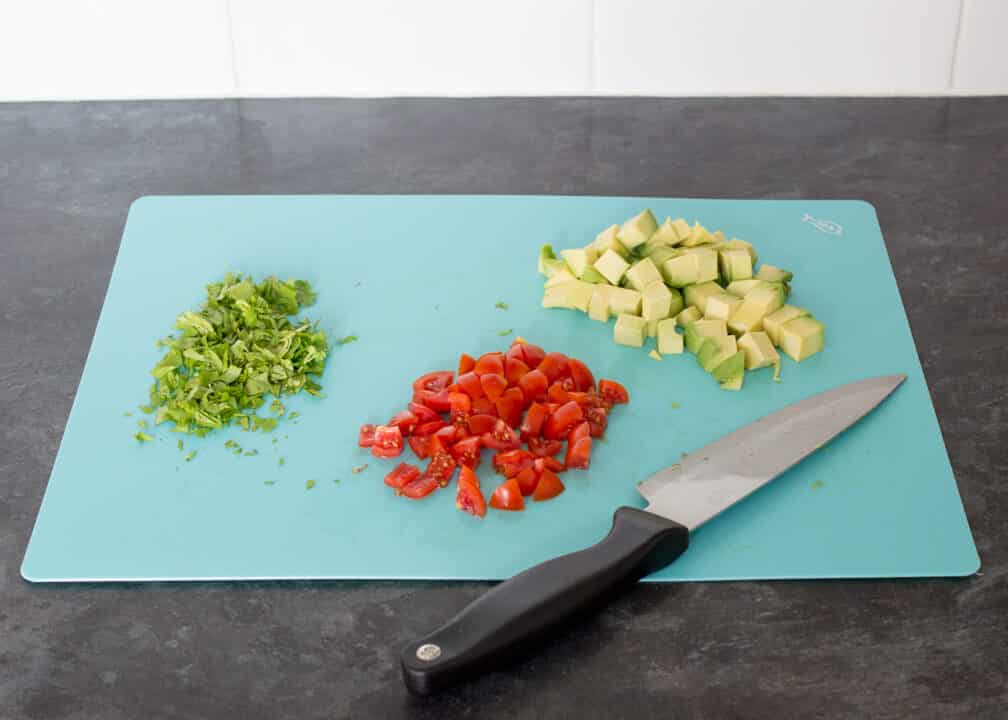 Chopped avocado, tomato and coriander on a board